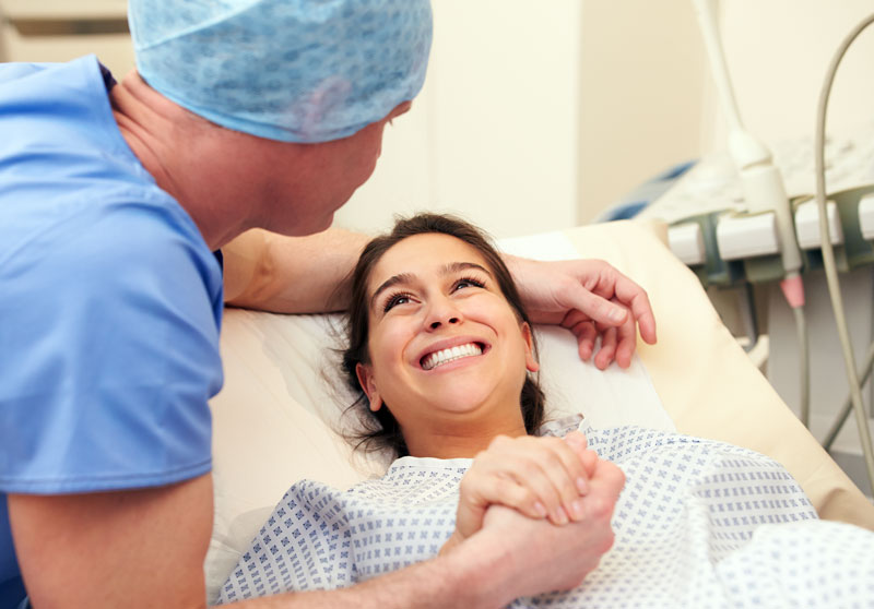 Husband-Supporting-Wife-Through-IVF-Treatment Husband holding his wife's hand before surgical procedure